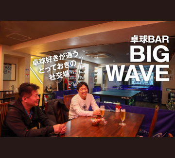 神戸初の卓球バーBIG WAVEの写真。卓球台があるバーで、男性二人が楽しそうにお酒を飲んでいます。